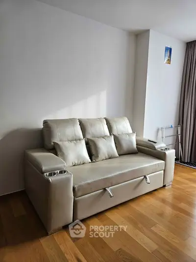Modern living room with sleek leather sofa and hardwood floors, perfect for stylish urban living.