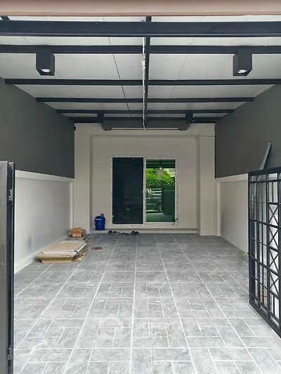 Spacious modern garage with tiled flooring and open layout, perfect for parking or storage.