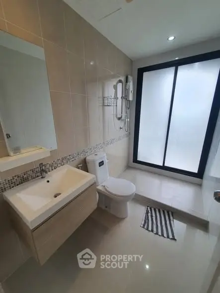Modern bathroom with sleek fixtures and large frosted glass window