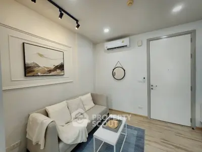 Modern living room with cozy sofa, stylish decor, and air conditioning, perfect for relaxation.