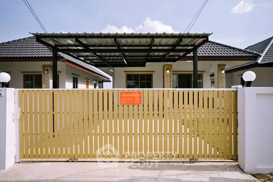 Modern single-story house with gated entrance and carport, perfect for family living.