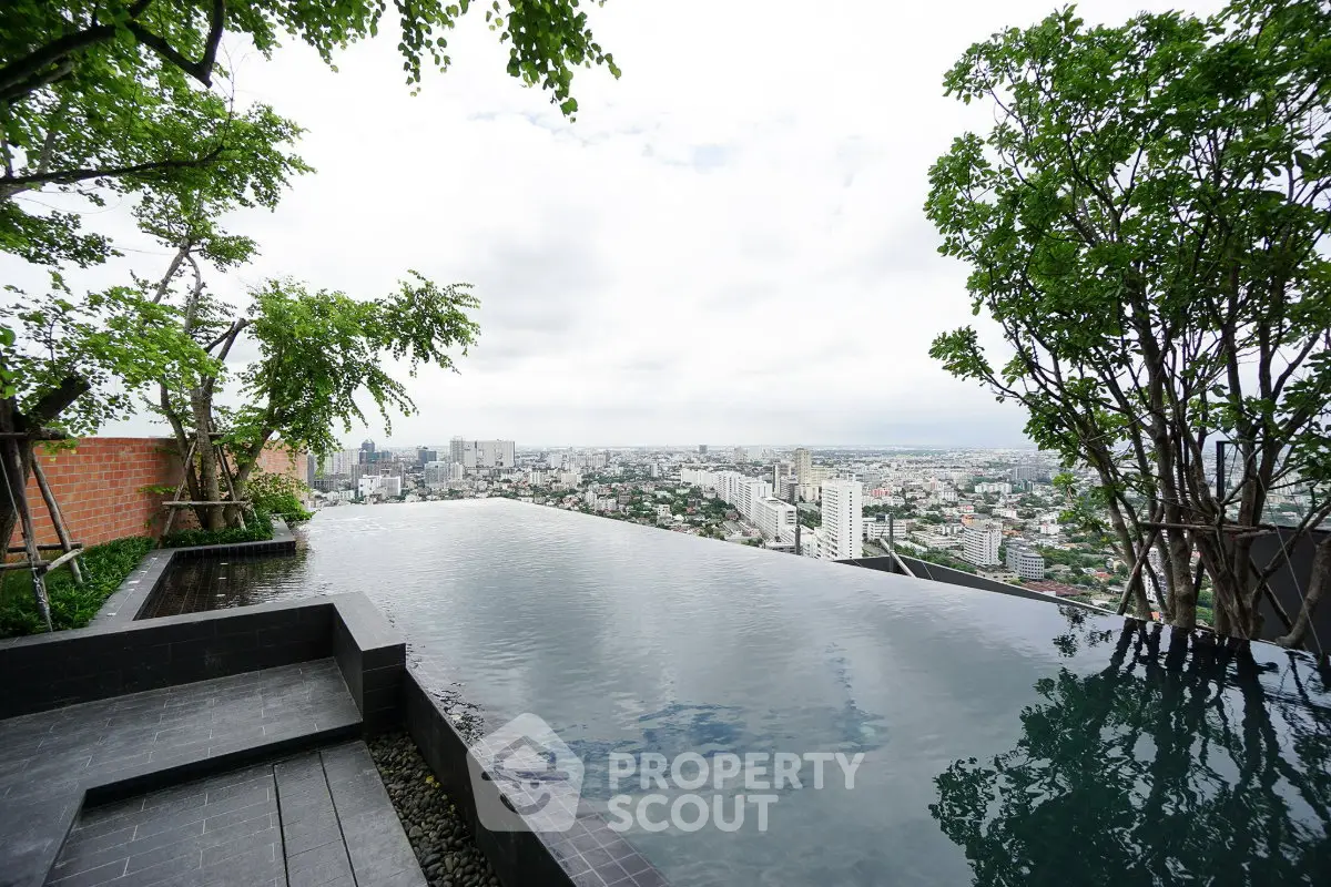 Stunning rooftop infinity pool with panoramic city views and lush greenery.