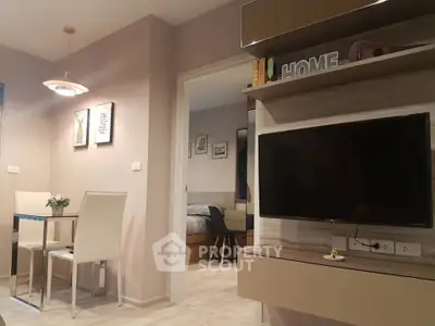 Modern living room with wall-mounted TV and dining area in stylish apartment