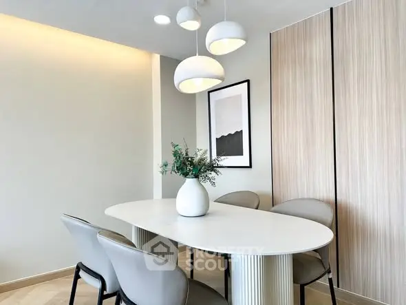 Modern dining area with elegant table, stylish chairs, and contemporary lighting in a chic apartment.