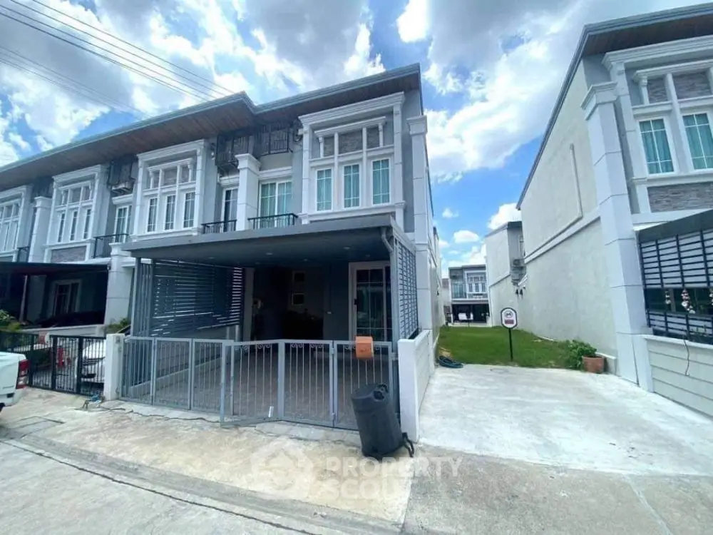 Modern townhouse exterior with gated driveway and contemporary design.