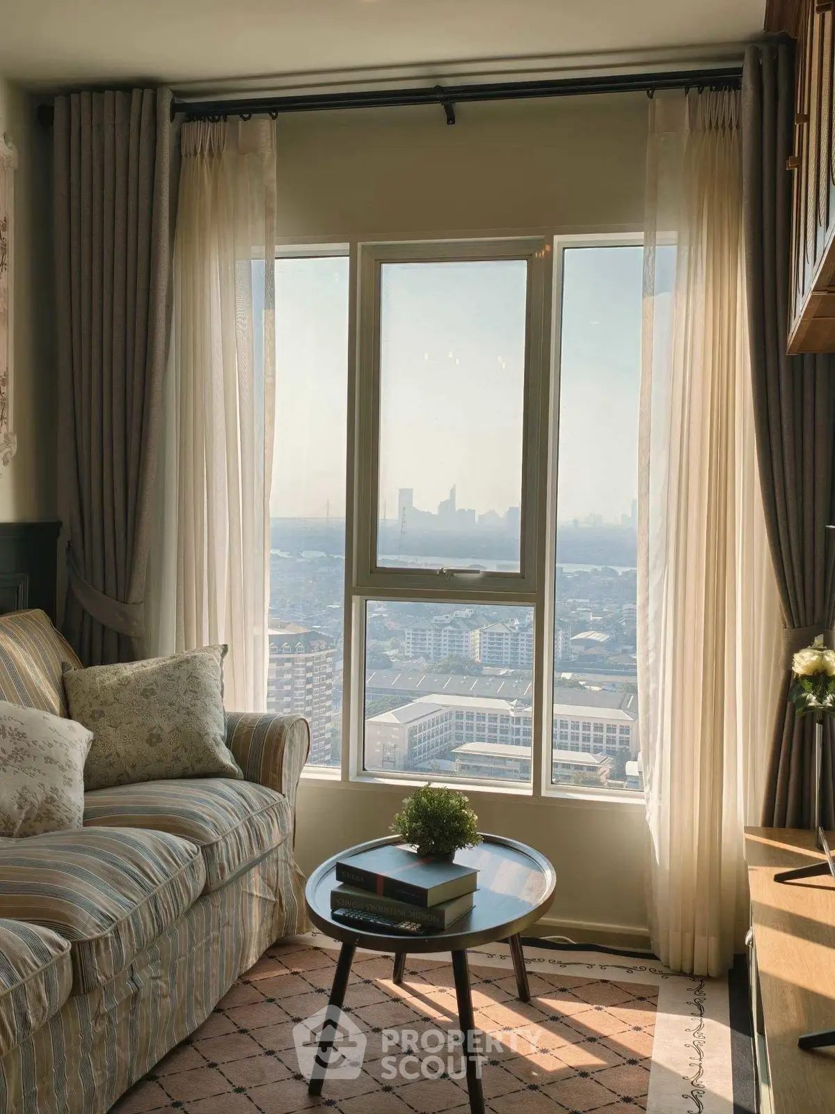 Cozy living room with stunning city view through large windows, featuring elegant decor and comfortable seating.