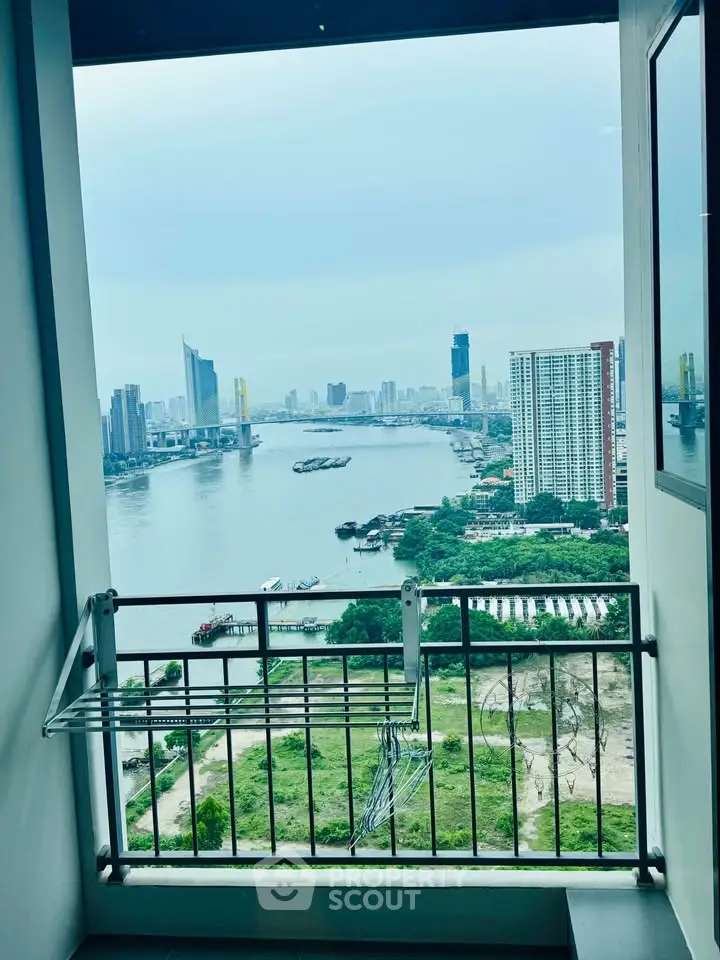 Stunning river view from high-rise balcony with city skyline backdrop, perfect for urban living.