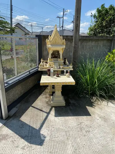 Charming outdoor spirit house in a serene garden setting, perfect for peaceful living.