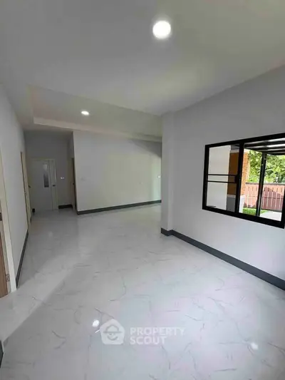 Spacious modern interior with large windows and sleek flooring, perfect for customization.
