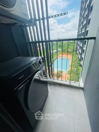 Compact balcony with washing machine and stunning pool view in modern high-rise apartment.