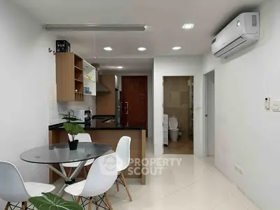 Modern open-layout kitchen and dining area with sleek design and air conditioning.