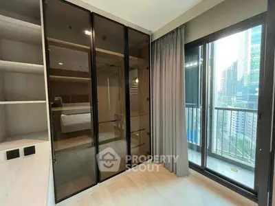 Modern bedroom with glass wardrobe and city view balcony