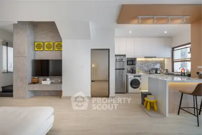 Modern open-plan living room and kitchen with stylish decor and appliances