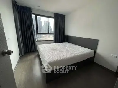 Modern bedroom with city view, featuring a large window and sleek design, perfect for urban living.