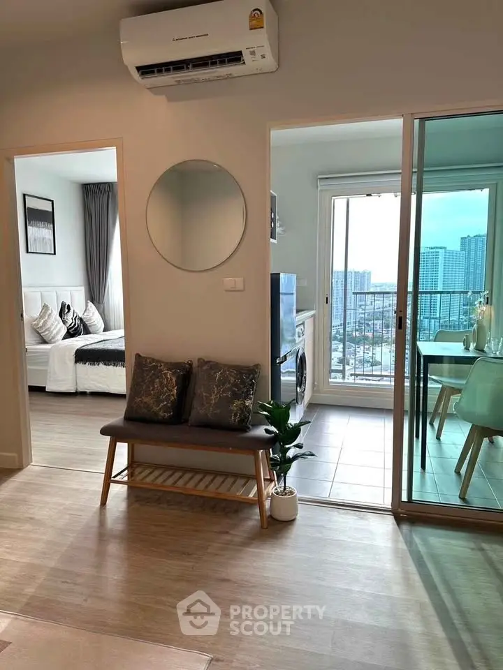 Modern apartment interior with open layout, featuring a cozy living area, stylish decor, and city view balcony.