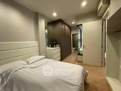 Modern bedroom with ensuite bathroom and sleek wooden wardrobe