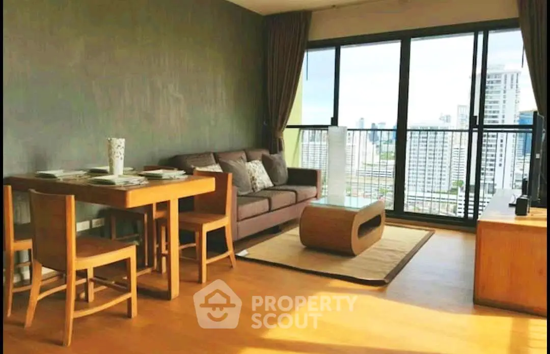 Spacious living room with city view, modern furniture, and large windows in a high-rise apartment.