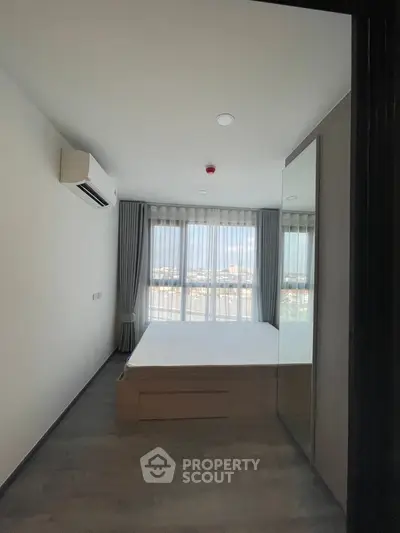 Modern bedroom with large window and air conditioning unit, featuring minimalist design.