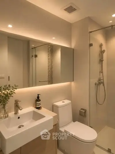 Modern bathroom with sleek design, glass shower, and elegant lighting.