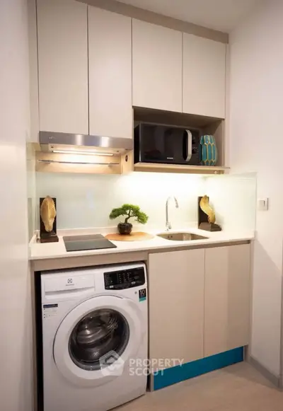 Modern compact kitchen with washing machine and sleek cabinetry
