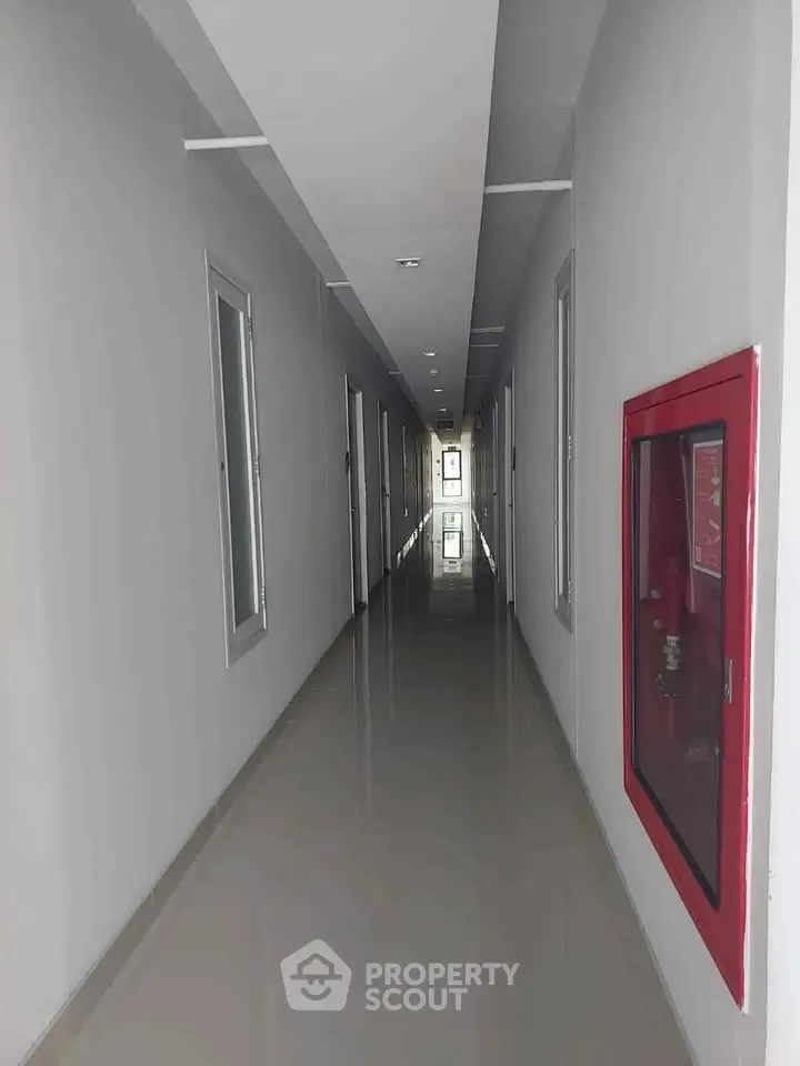 Modern apartment corridor with sleek design and fire safety equipment.