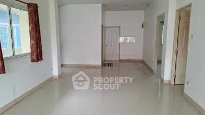 Spacious empty room with glossy tiled floors and large windows, ideal for customization.