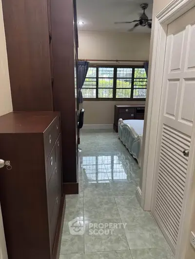 Cozy bedroom with ample natural light and elegant wooden furniture, perfect for relaxation and comfort.