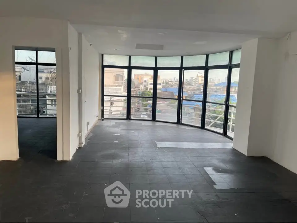 Spacious modern living room with large windows offering panoramic city views.