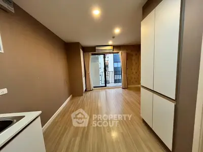 Spacious modern living room with balcony access and sleek wooden flooring