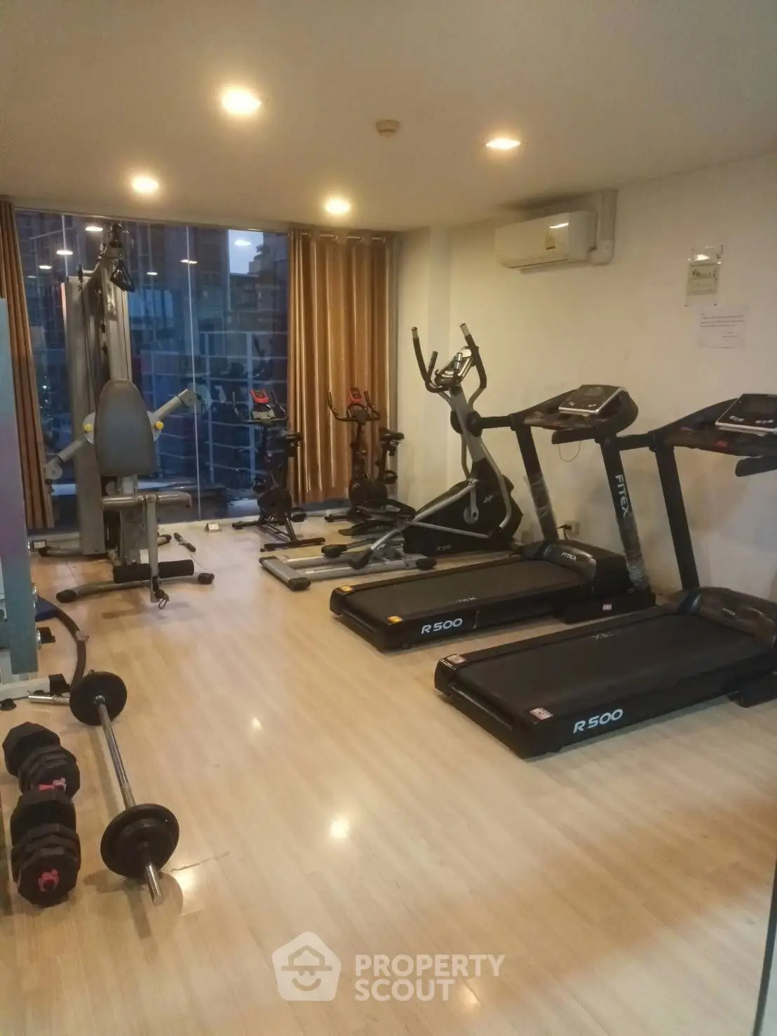 Modern gym with treadmills and exercise equipment in a well-lit room
