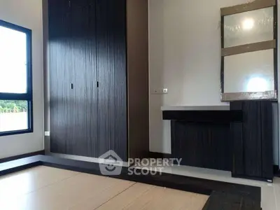 Modern bedroom with built-in wardrobe and stylish vanity in a bright, minimalist design.