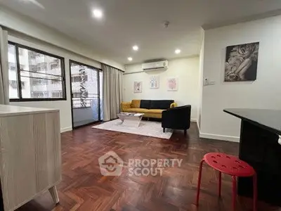 Spacious living room with modern decor and balcony access in urban apartment.