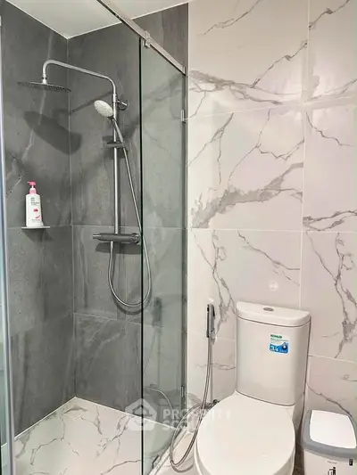 Modern bathroom with elegant marble tiles and glass shower enclosure