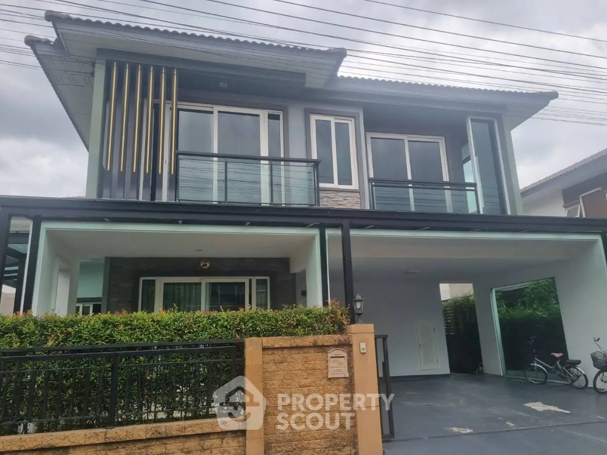 Modern two-story house with sleek design and spacious driveway in a suburban neighborhood.