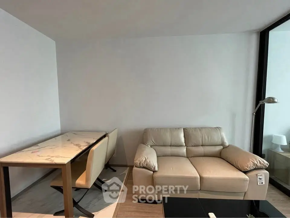 Modern living room with beige sofa and marble dining table in a stylish apartment.
