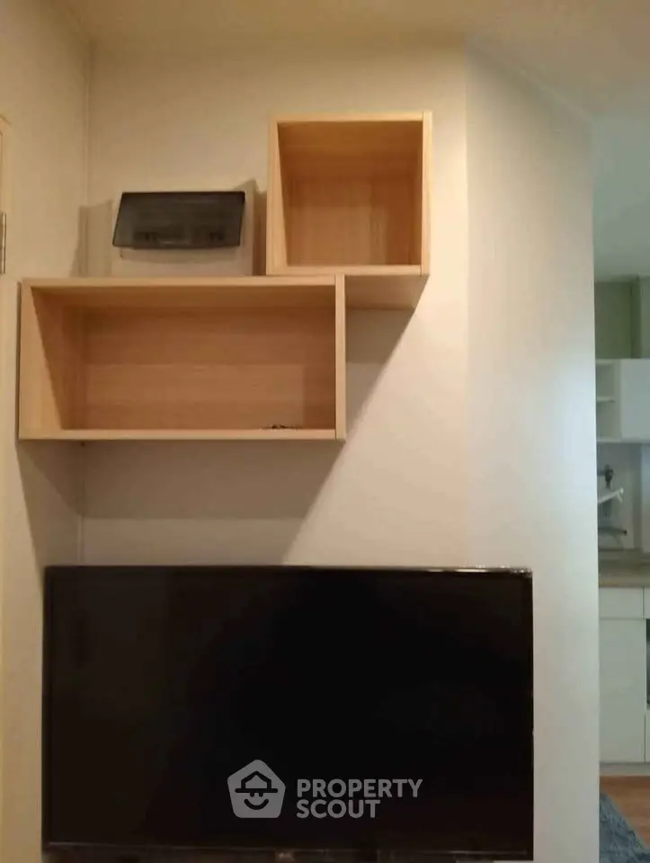Modern living room with sleek wall-mounted TV and stylish wooden shelves.