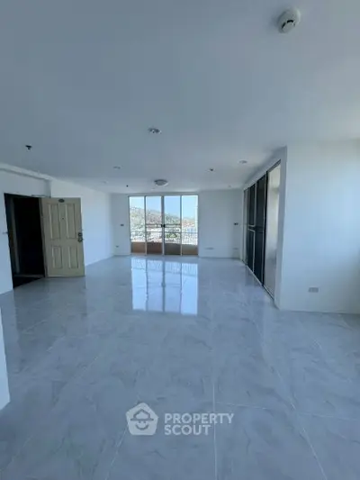 Spacious living room with large windows offering a stunning view, perfect for modern living.