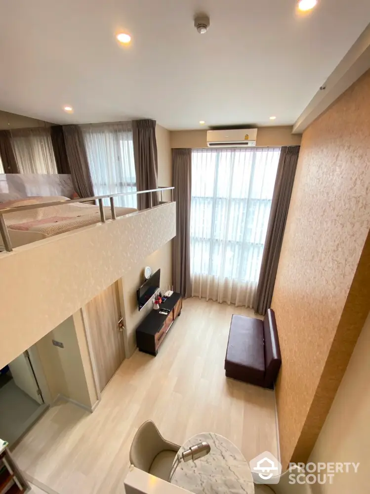 Spacious multi-level living area with modern design, ample lighting, and a cozy loft bedroom, perfect for urban living.