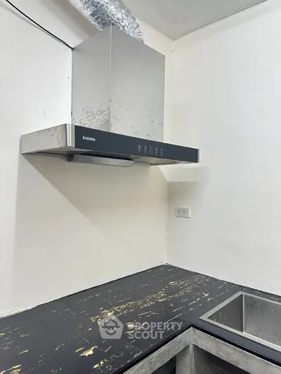Modern kitchen with sleek black countertop and stainless steel range hood