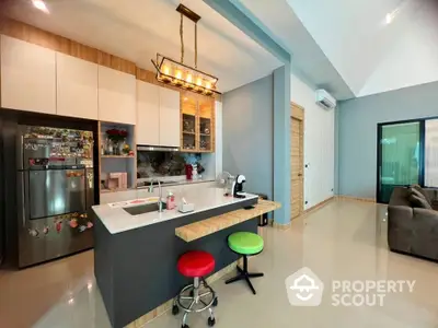 Modern open-layout kitchen with island and stylish lighting in a spacious home.