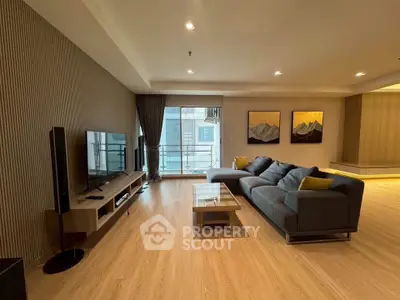 Spacious modern living room with large sofa and flat-screen TV, perfect for relaxation.