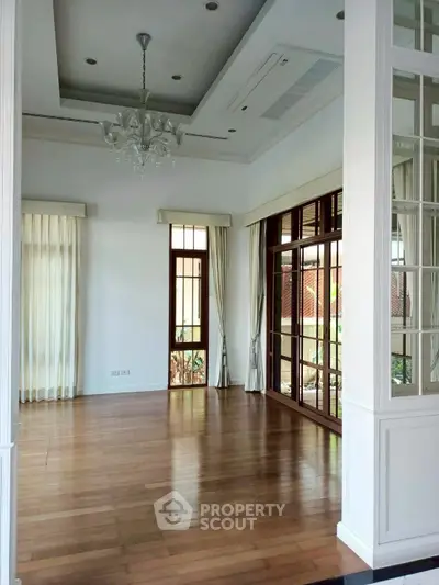 Elegant living room with hardwood floors and large windows in a luxury home