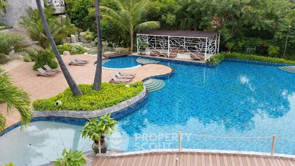Luxurious outdoor pool area with lush greenery and stylish lounge chairs, perfect for relaxation and leisure.