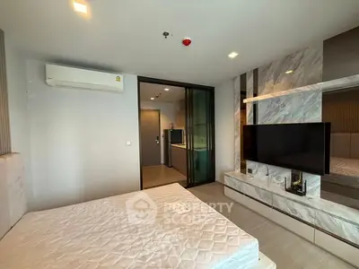 Modern bedroom with sleek design, featuring a wall-mounted TV and air conditioning unit.