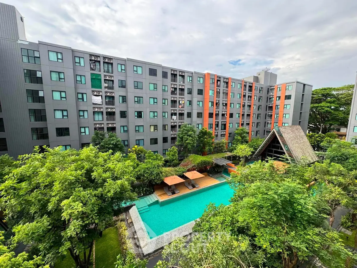 Modern apartment complex with lush greenery and inviting swimming pool view