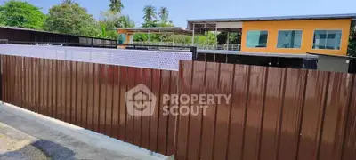 Modern building exterior with vibrant yellow facade and lush greenery