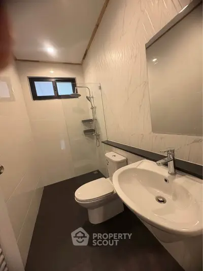 Modern bathroom with sleek fixtures and a spacious shower area, perfect for contemporary living.