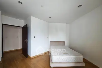 Spacious bedroom with minimalist design and wooden flooring, perfect for customization.