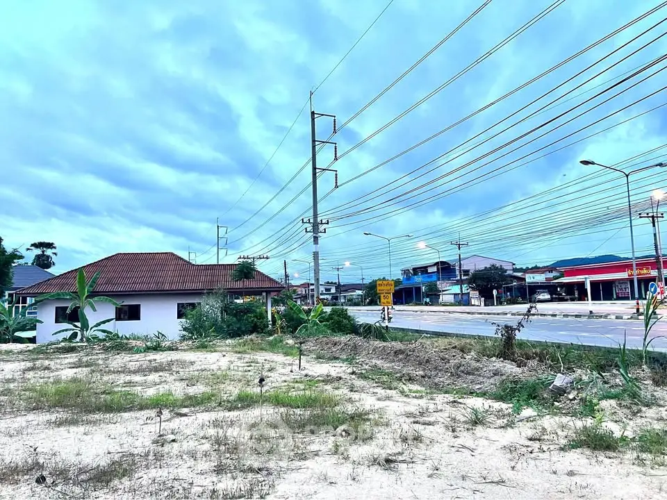 Vacant land with potential for development near a busy road and residential area.