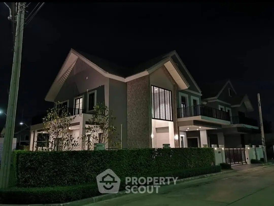 Stunning modern house exterior with lush greenery and elegant night lighting.
